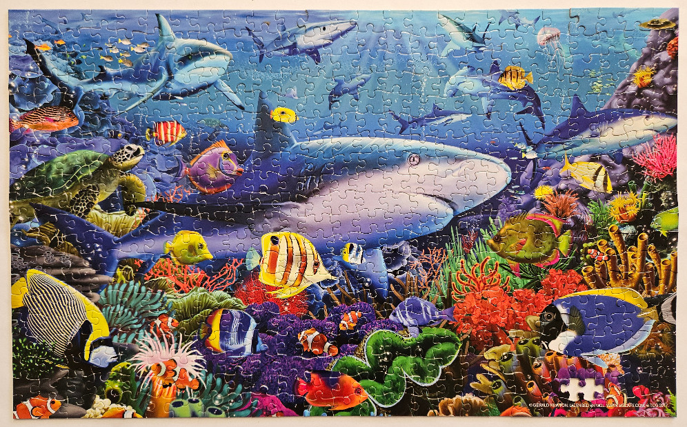 Vibrant underwater scene featuring a large shark surrounded by tropical fish and coral reef life.