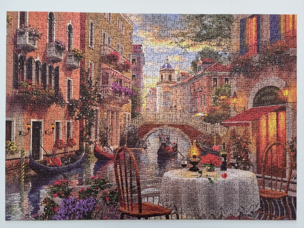 A romantic scene in Venice with a canal, gondolas, and a table set for two.