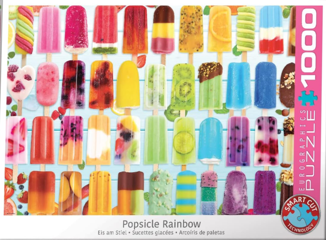 A colourful grid of various fruit and flavoured popsicles arranged on a light blue wooden background.