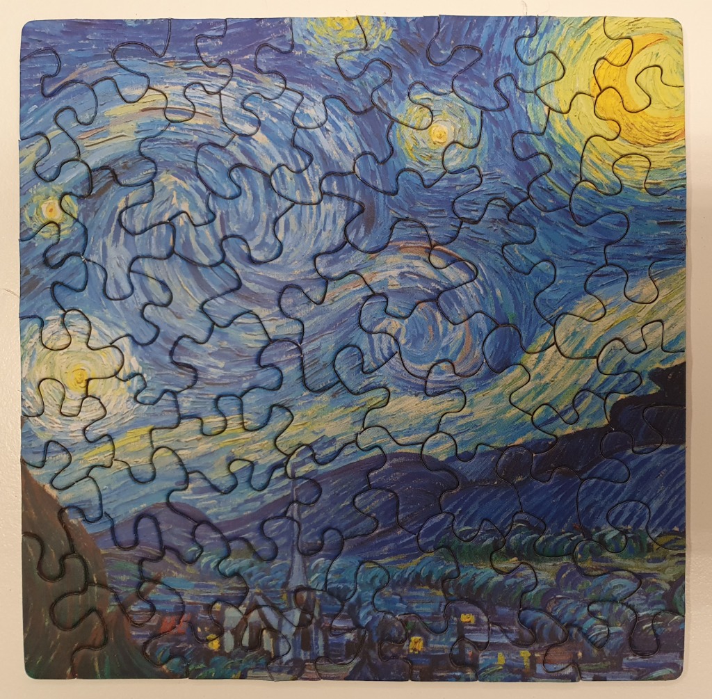 A reproduction of Van Gogh's The Starry Night painting featuring swirling blue skies, a crescent moon, and a quiet village.