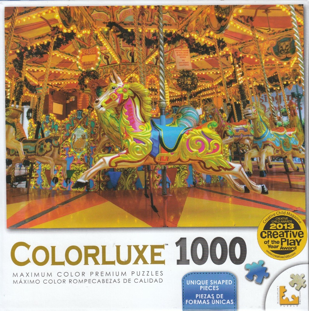 A close-up photograph of a brightly painted carousel with ornate horses under glowing golden lights.