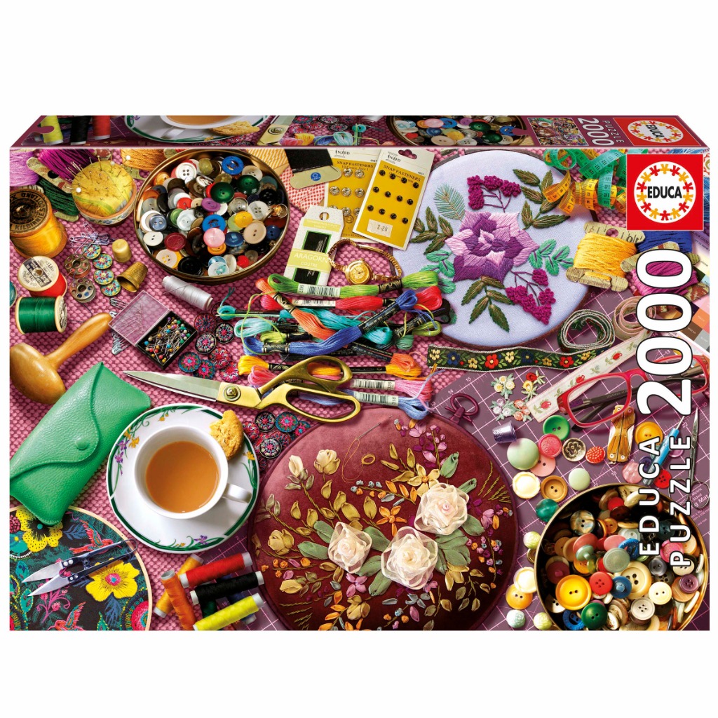 A top-down view of sewing and embroidery supplies scattered across a cutting mat