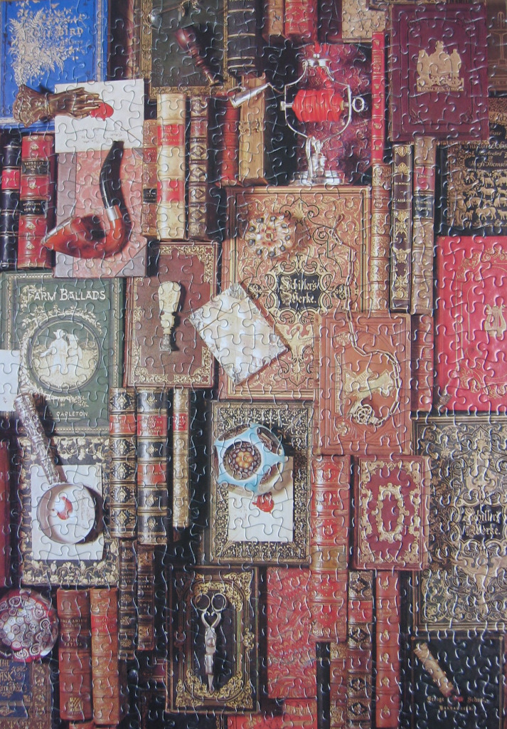 A close-up view of antique books stacked and laid out, featuring rich red, brown, and gold decorative covers.