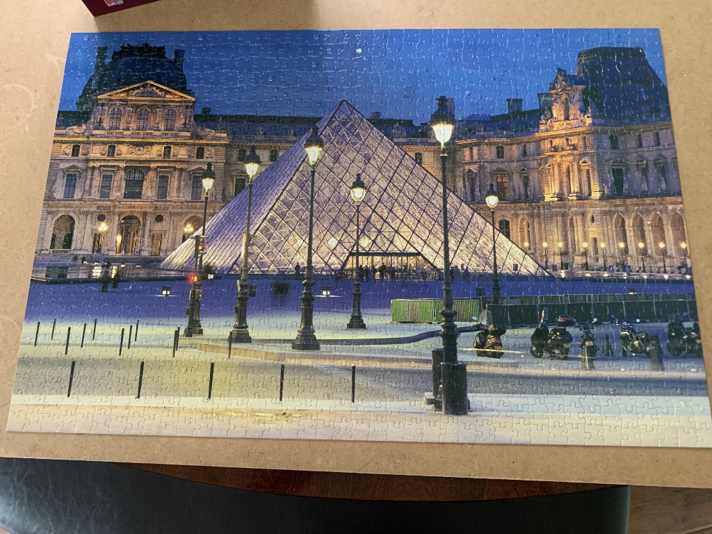 The Louvre Museum glass pyramid illuminated at twilight in Paris.