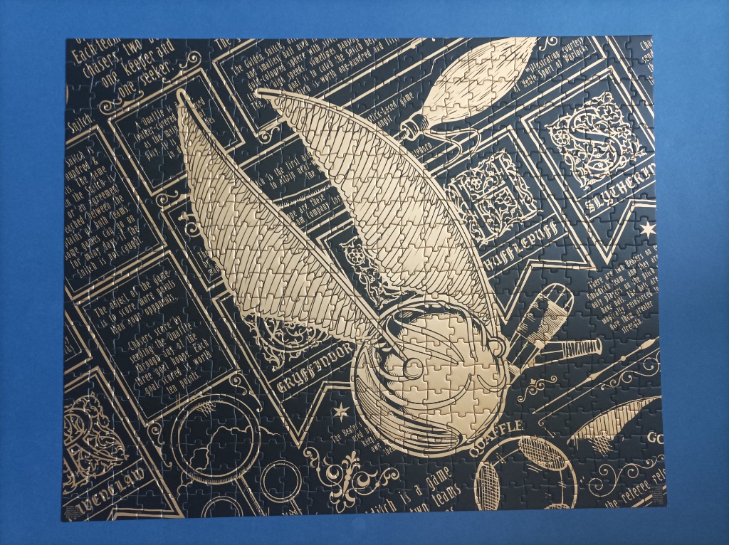 A golden snitch illustration surrounded by wizarding world text on a black background.