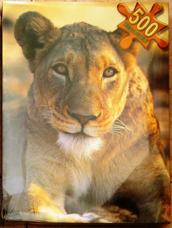 Close-up portrait of a lioness with golden fur against a soft, sunlit savannah background.