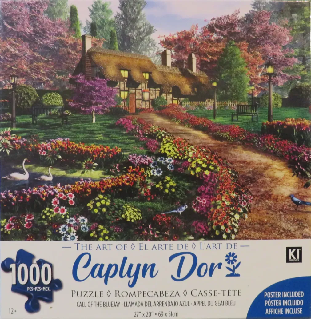 A thatched-roof cottage garden in spring with two swans on a pond and a dirt path leading to the house.