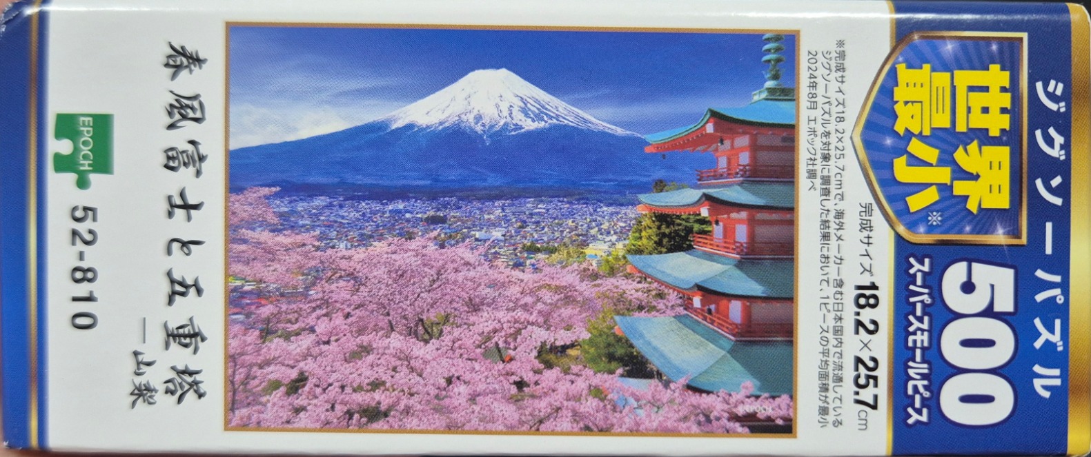 Mt. Fuji with pagoda amid pink cherry blossoms under a blue sky.