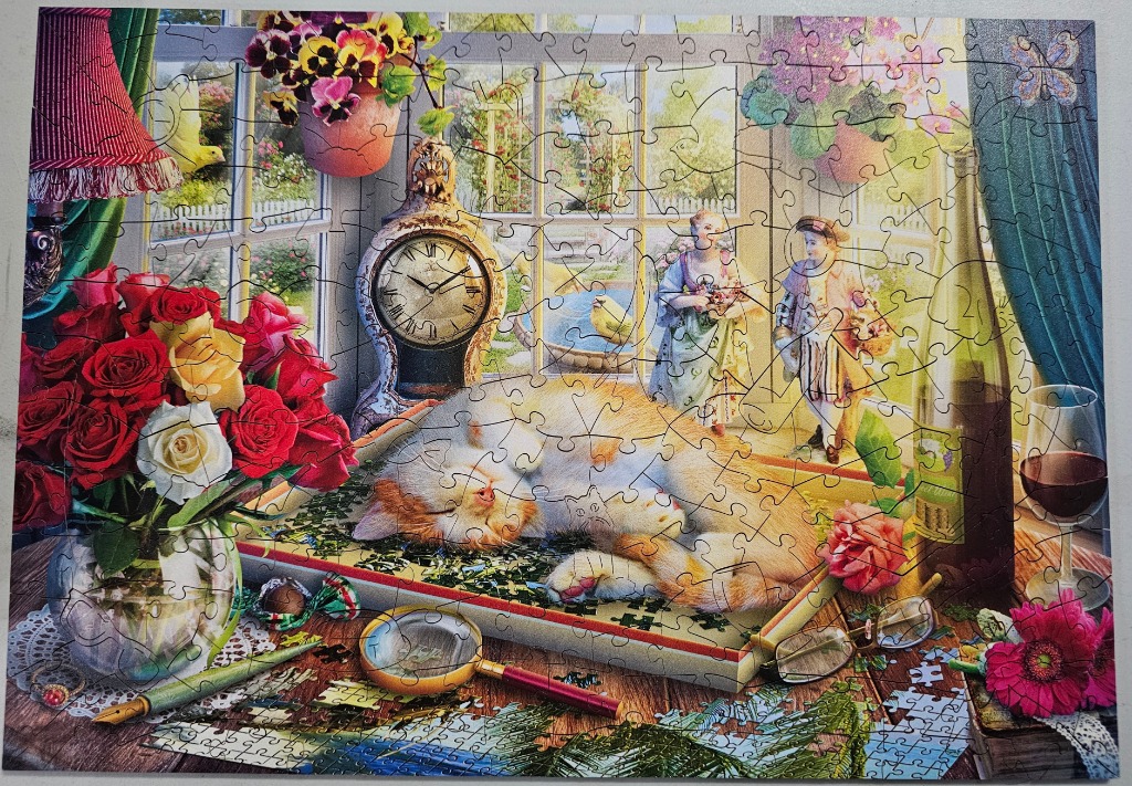 A cozy still life featuring a sleeping ginger cat on a table with flowers, a clock, and a window view.