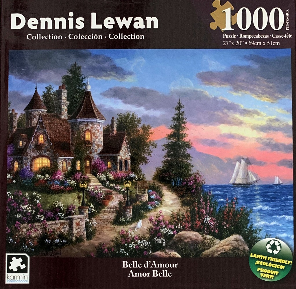 A stone cottage with turrets overlooking a calm sea at sunset with a white cat on a garden path.