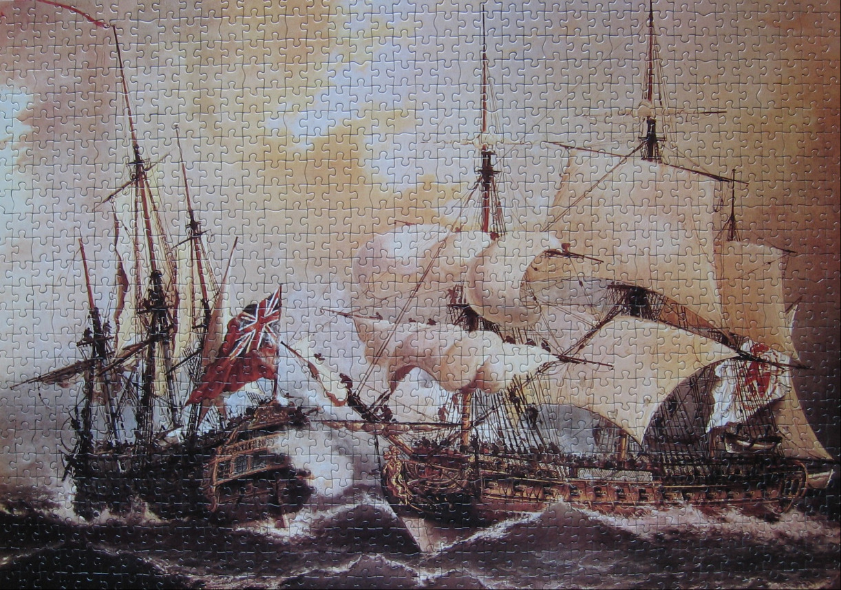 Two historical wooden tall ships sailing on a choppy ocean under a hazy, golden sky.