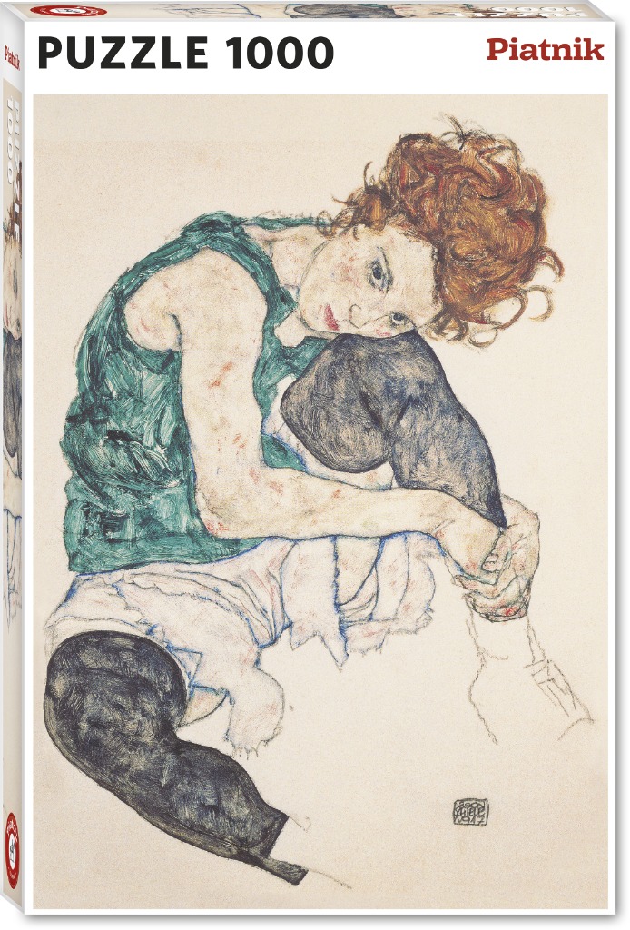 Portrait of a young woman with curly red hair, hunched in a seated position against a plain background.