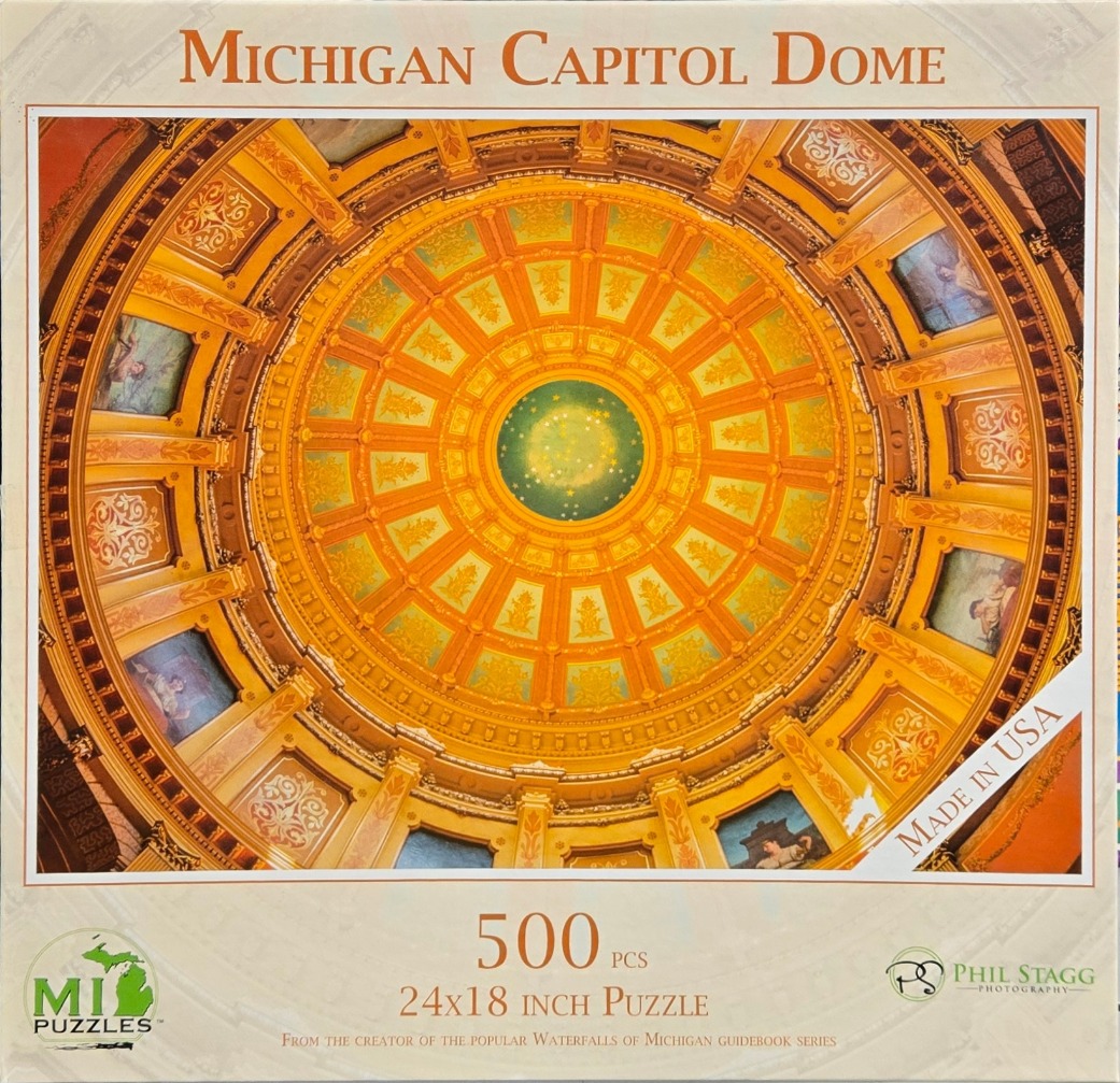 A low-angle, circular photograph looking directly up at the ornate, golden, domed ceiling of the Michigan Capitol.