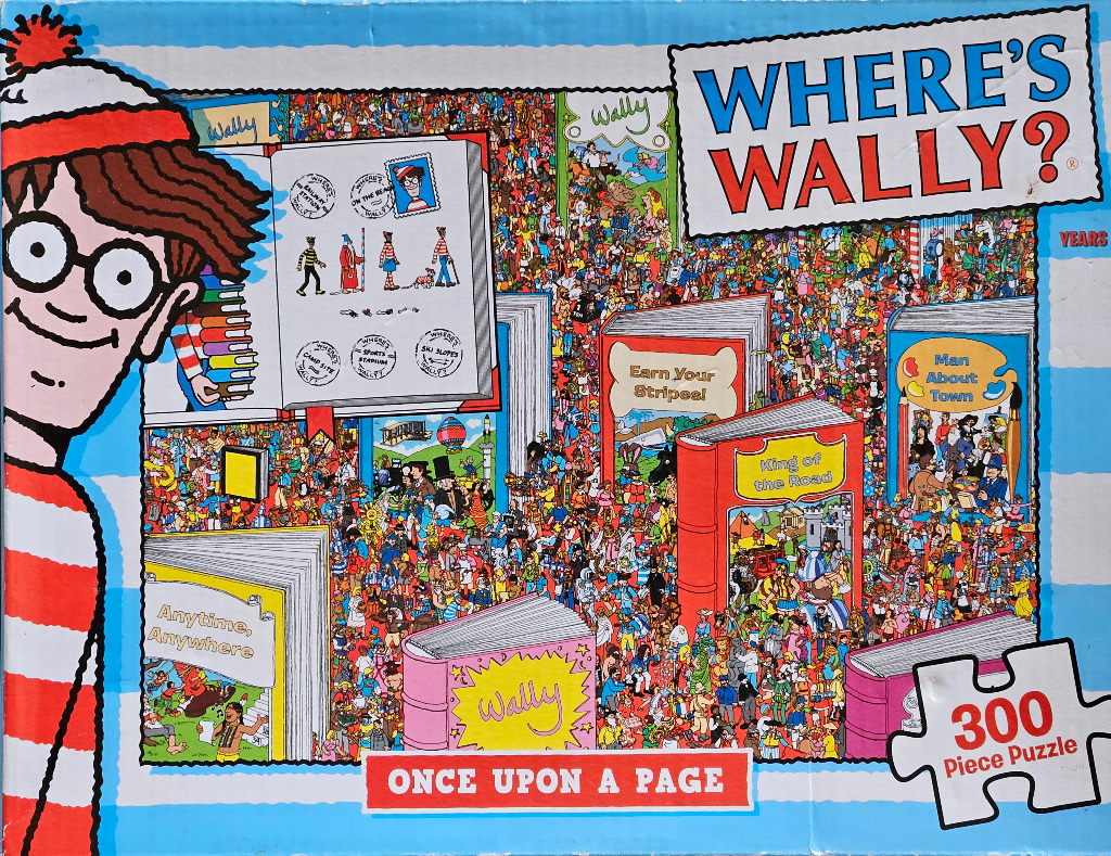A cluttered cartoon scene featuring a large close-up of Wally on the left and various books containing busy illustrations.