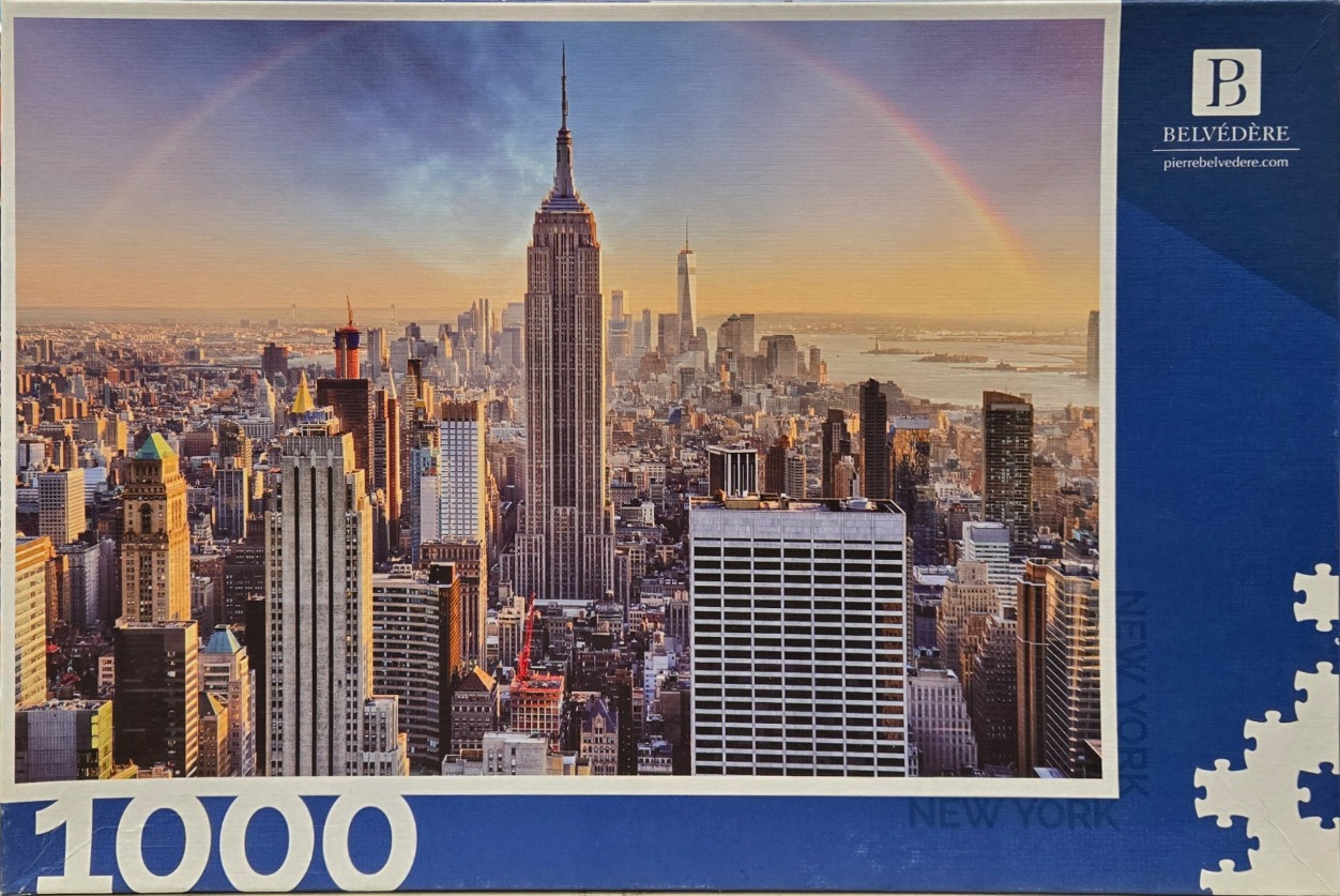 Panoramic view of the New York City skyline at sunset with a rainbow over the Empire State Building.