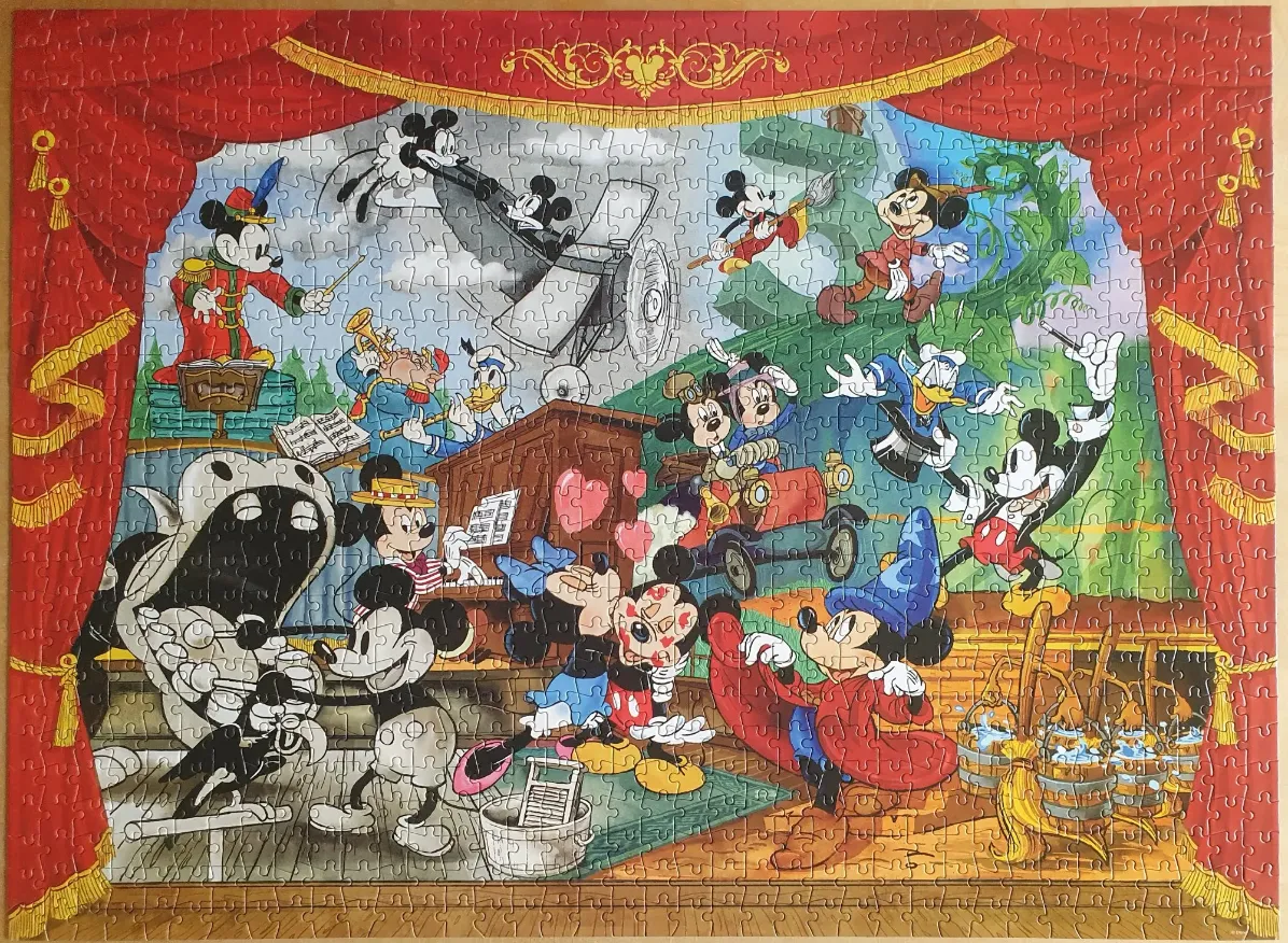 A theatrical stage scene featuring Mickey Mouse and friends in various iconic roles, framed by red velvet curtains.