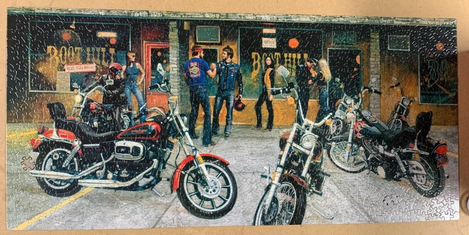 A group of bikers and their motorcycles outside a saloon called Boot Hill.
