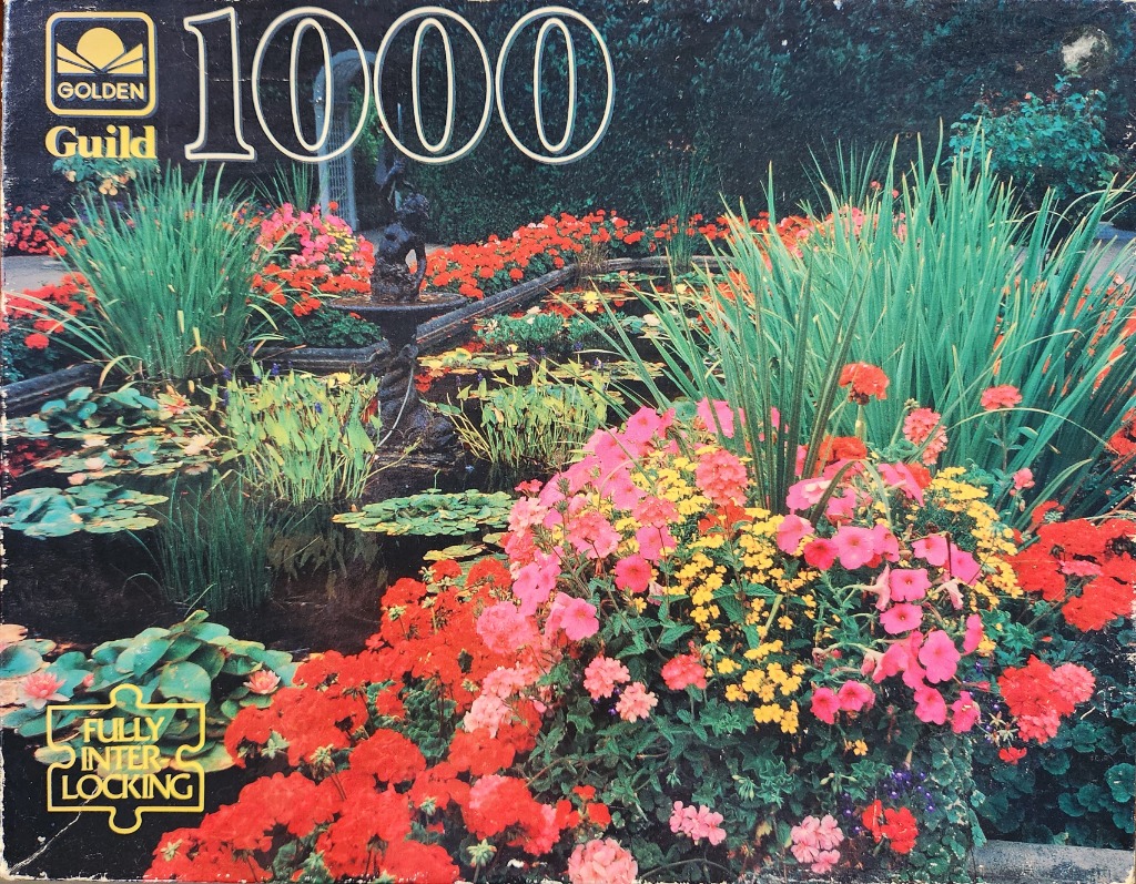 A lush garden pond filled with vibrant red, pink, and yellow flowers and water lilies