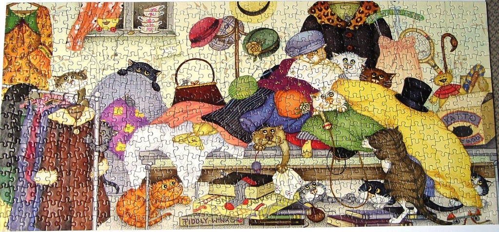 Whimsical illustration of numerous cats exploring and playing among a collection of vintage clothing, hats, and accessories.