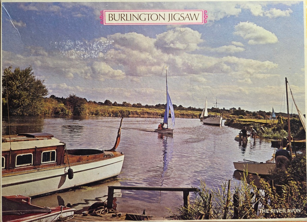 A peaceful scene of sailboats and a motor cruiser on the River Avon under a cloudy sky.