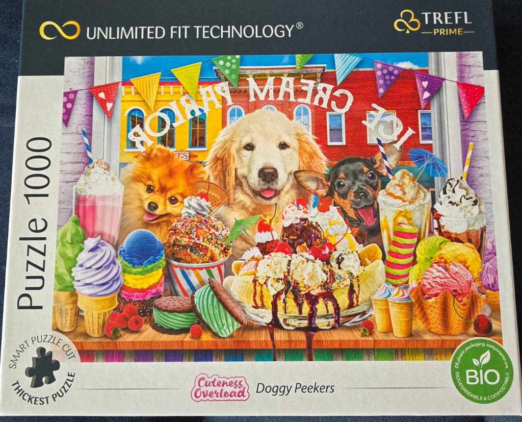 A golden retriever, a Pomeranian, and a chihuahua behind a counter filled with colourful ice cream treats.