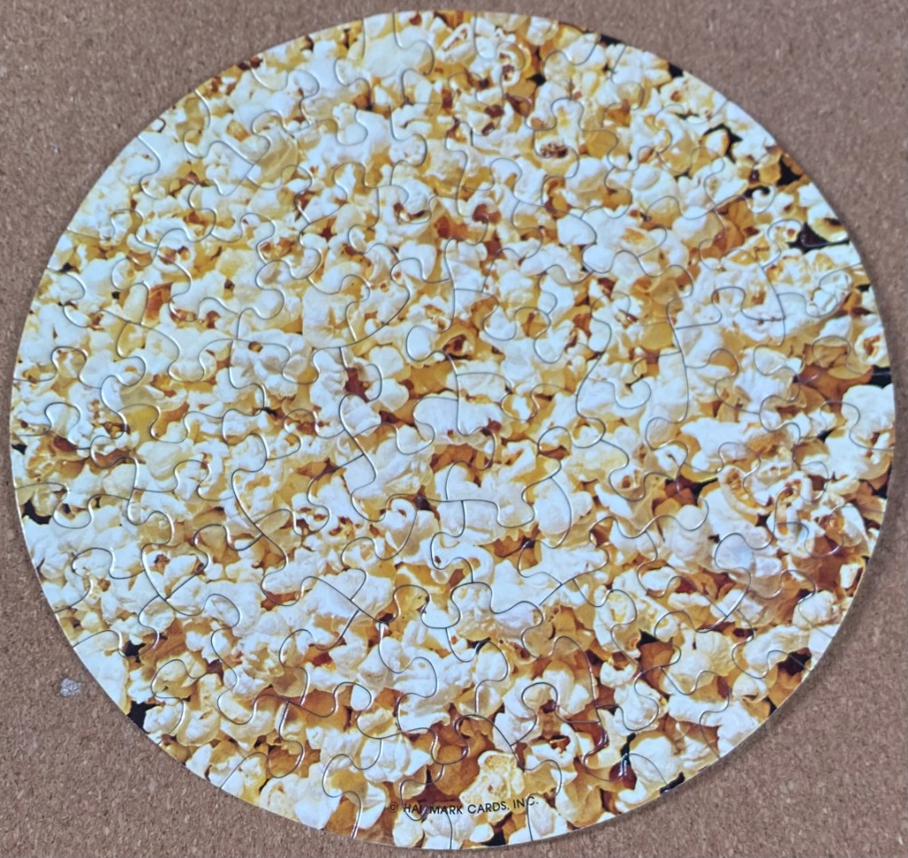 A close-up, circular overhead view of a pile of freshly popped popcorn.