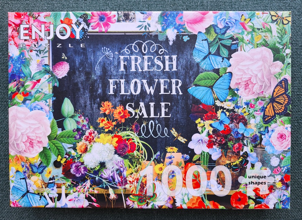 A chalkboard sign surrounded by vibrant flowers and butterflies with the text Fresh Flower Sale.