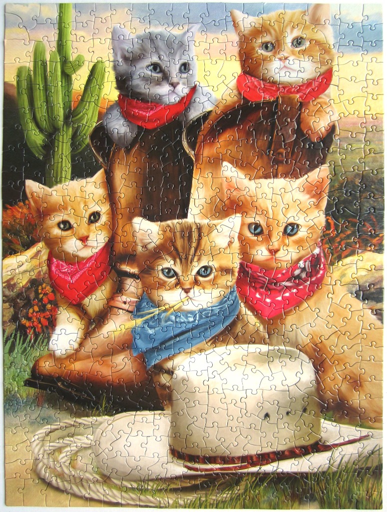 Four kittens wearing colorful bandanas posing with western-style boots and a cowboy hat.