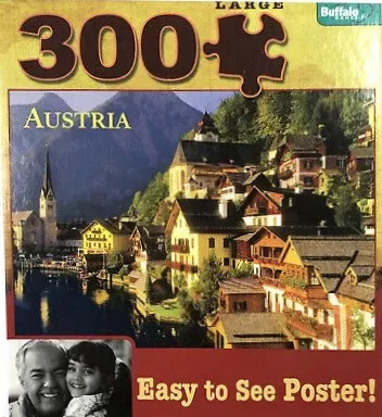 A scenic photograph of the Austrian village of Hallstatt nestled against a mountainside beside a lake.