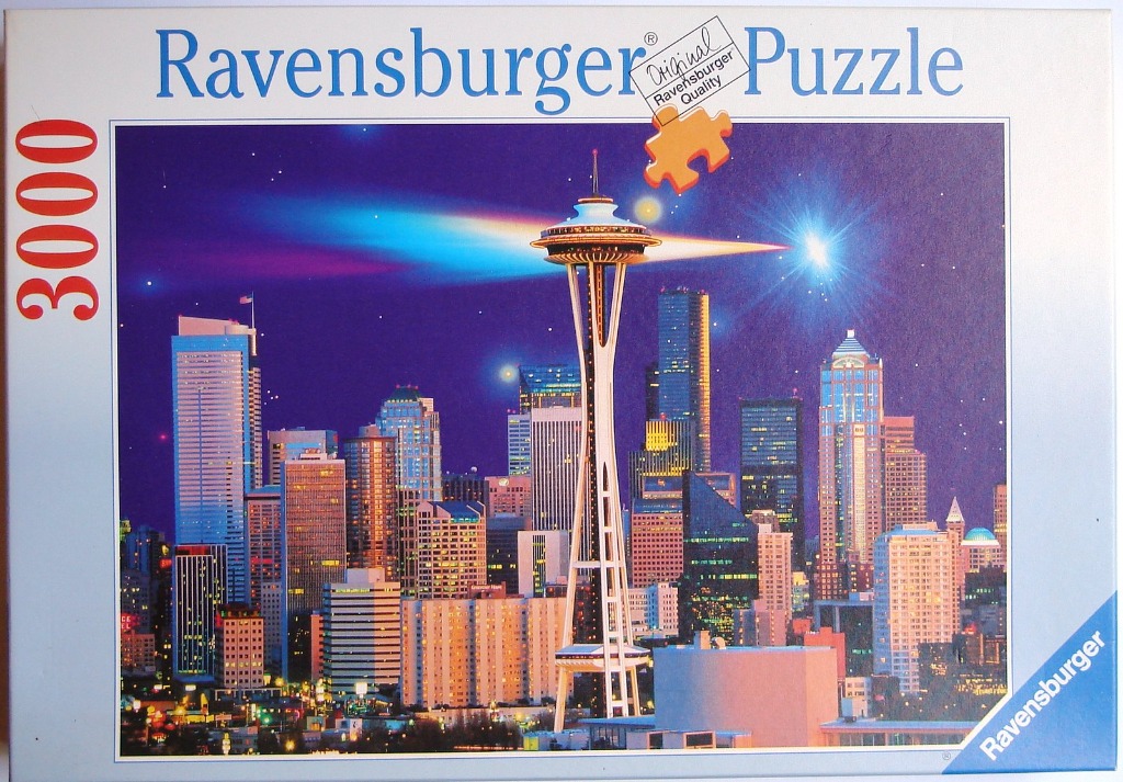 A nighttime view of the Seattle skyline with the Space Needle illuminated against a starry purple sky.
