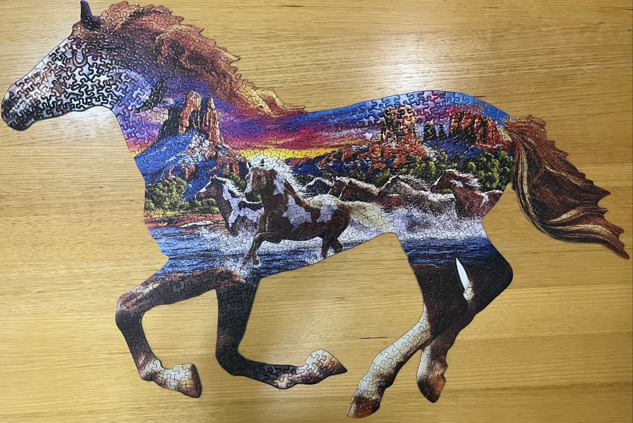 A shaped image of a running horse filled with a vibrant sunset landscape scene featuring wild horses and red rock formations.