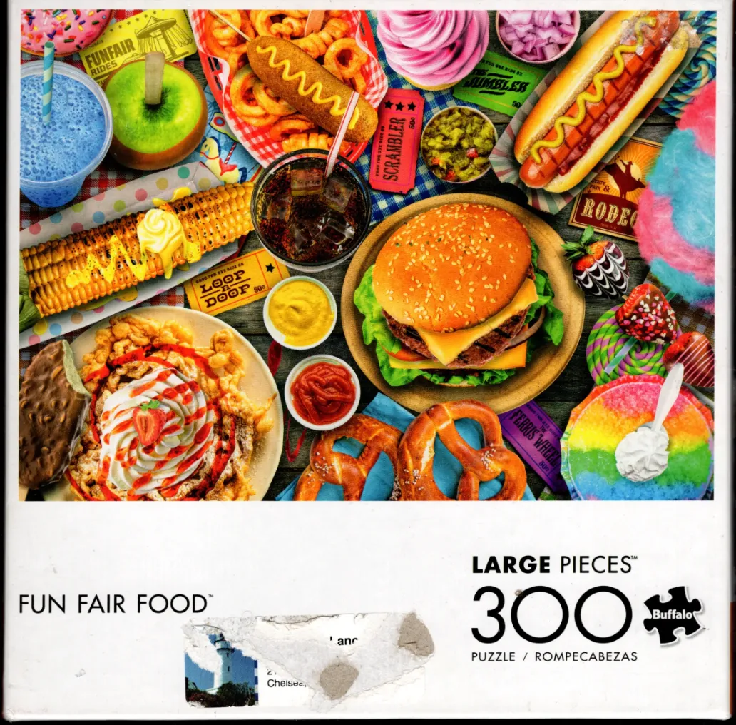 A top-down view of various colorful fairground foods scattered on a rustic wooden surface.