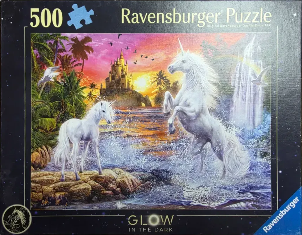 Two white unicorns on a rocky shore with a castle and waterfall in the background at sunset.