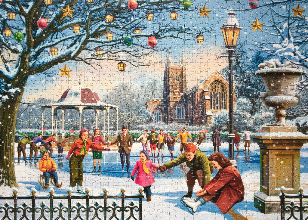 A nostalgic, snow-covered winter scene showing people ice skating in front of a stone church and bandstand.