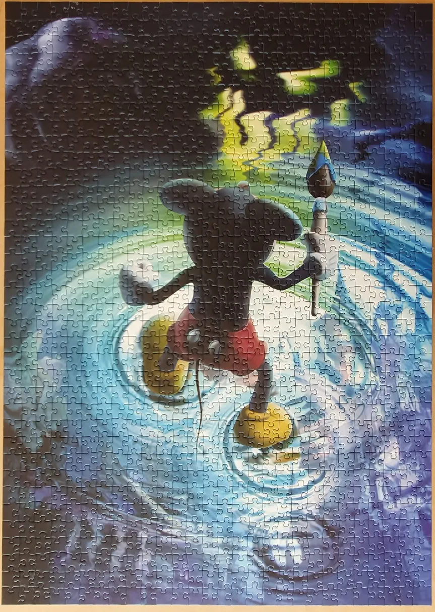 Mickey Mouse standing in water with a paintbrush, reflecting a magical light.