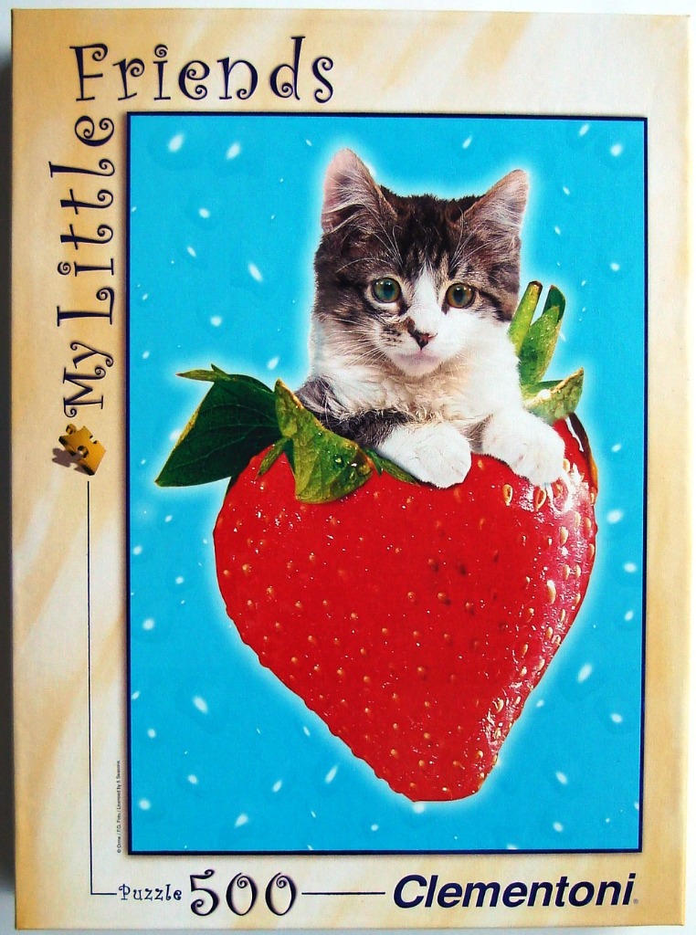 A cute tabby kitten sitting inside a giant, bright red strawberry against a vibrant blue background.