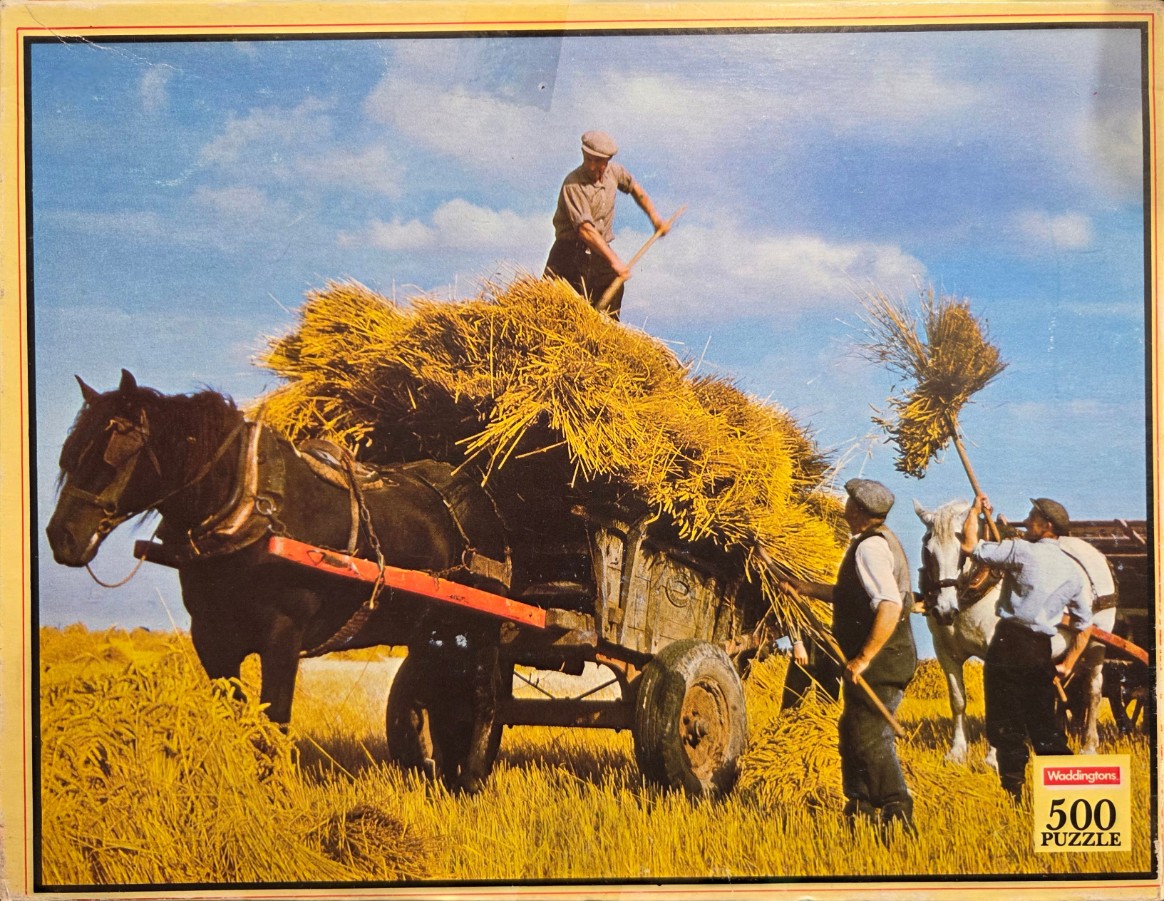 Three men harvesting wheat onto a horse-drawn cart in a sunny field.