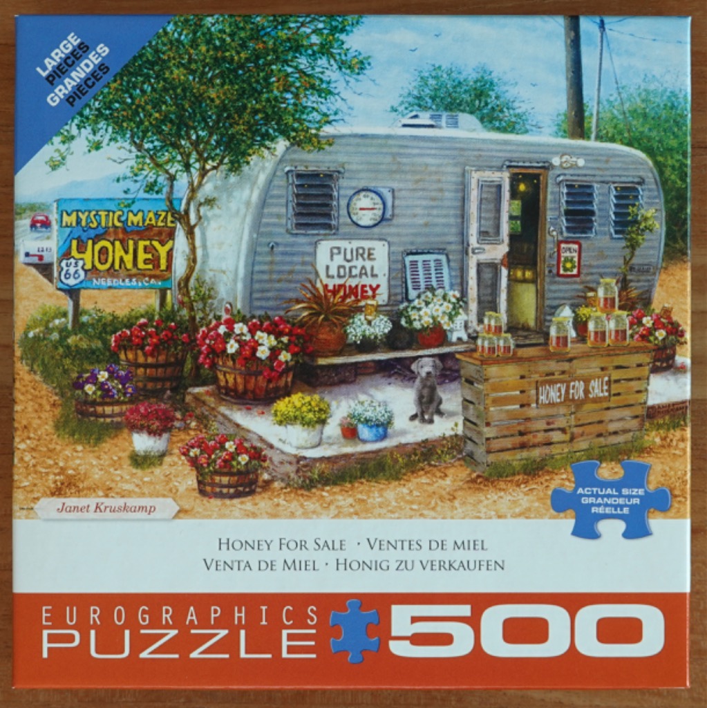 A vintage silver travel trailer serves as a roadside honey stand, surrounded by flower pots and a small dog.