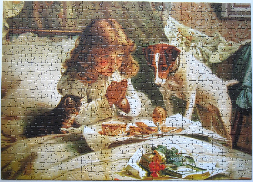 A young girl with long brown hair saying grace at a table with a cat and a dog.