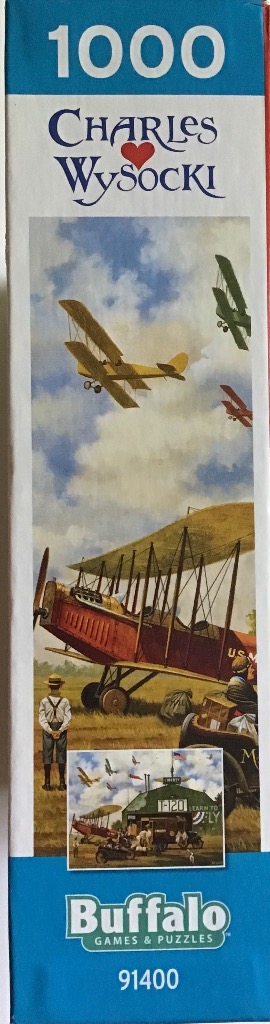 Painting of vintage biplanes flying over a field with a small plane on the ground and a man looking up.