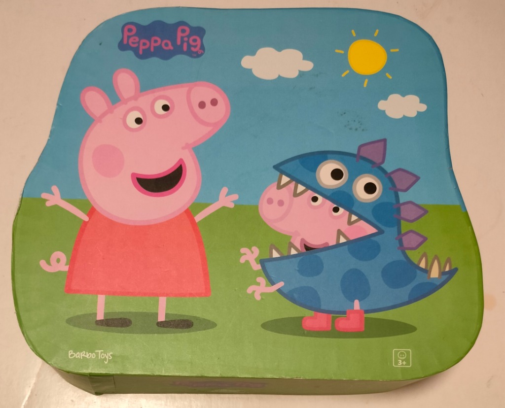 Peppa Pig standing next to a character wearing a blue dinosaur costume on a sunny grassy hill.