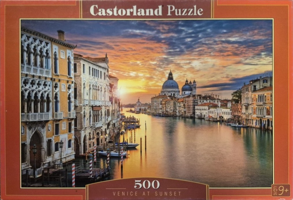 A photograph of a Venetian canal at sunset with historic buildings and the Santa Maria della Salute basilica in the distance.