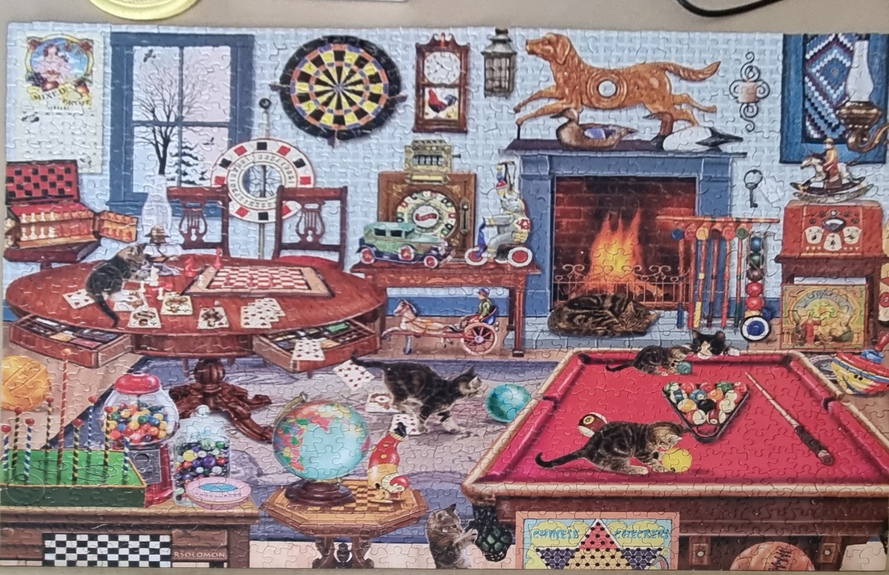 A cozy, cluttered game room featuring cats playing among billiards, board games, and vintage toys by a fireplace.
