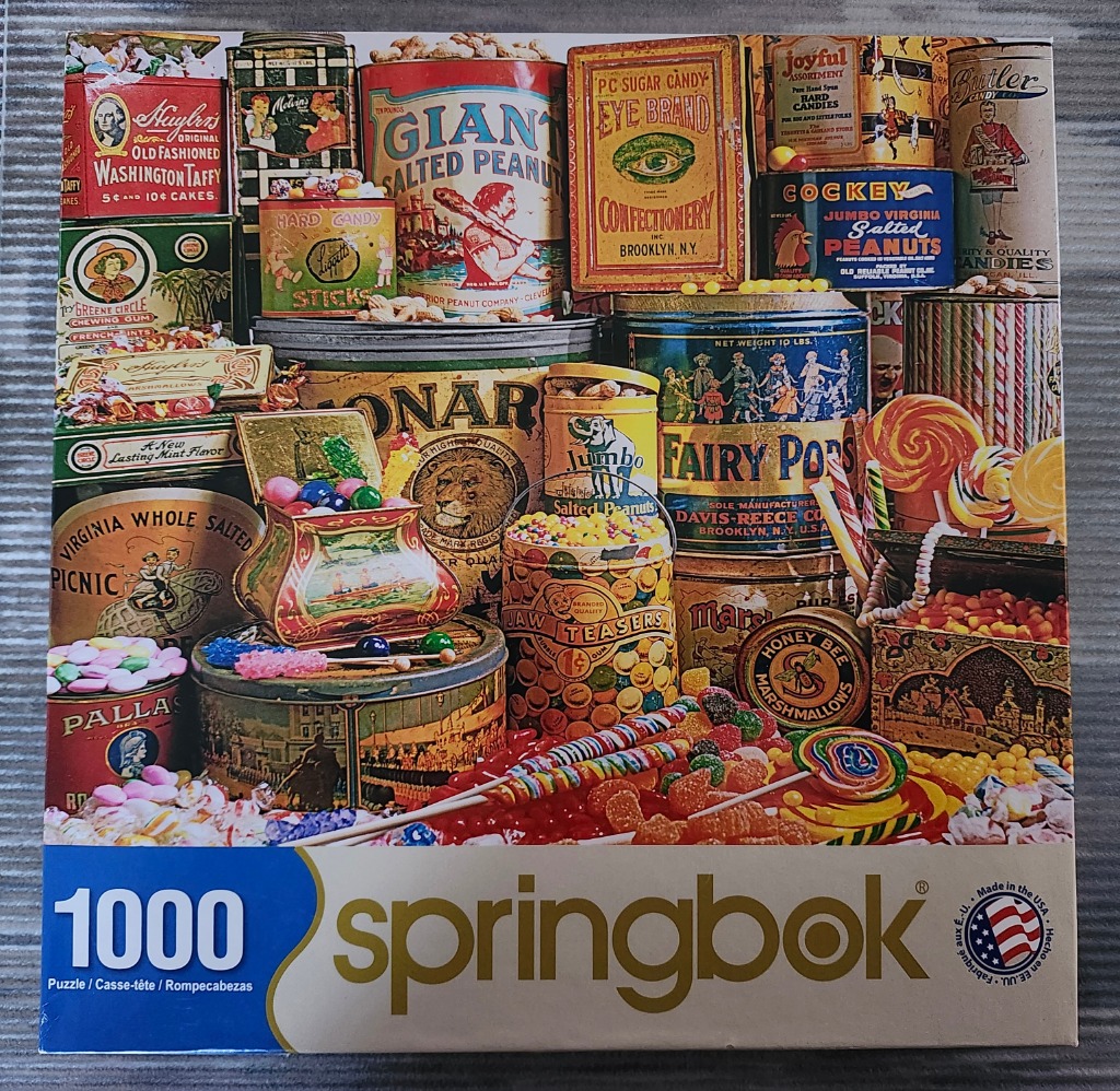 Vintage candy tins, confectionary jars, and assorted sweets stacked in a nostalgic still life.