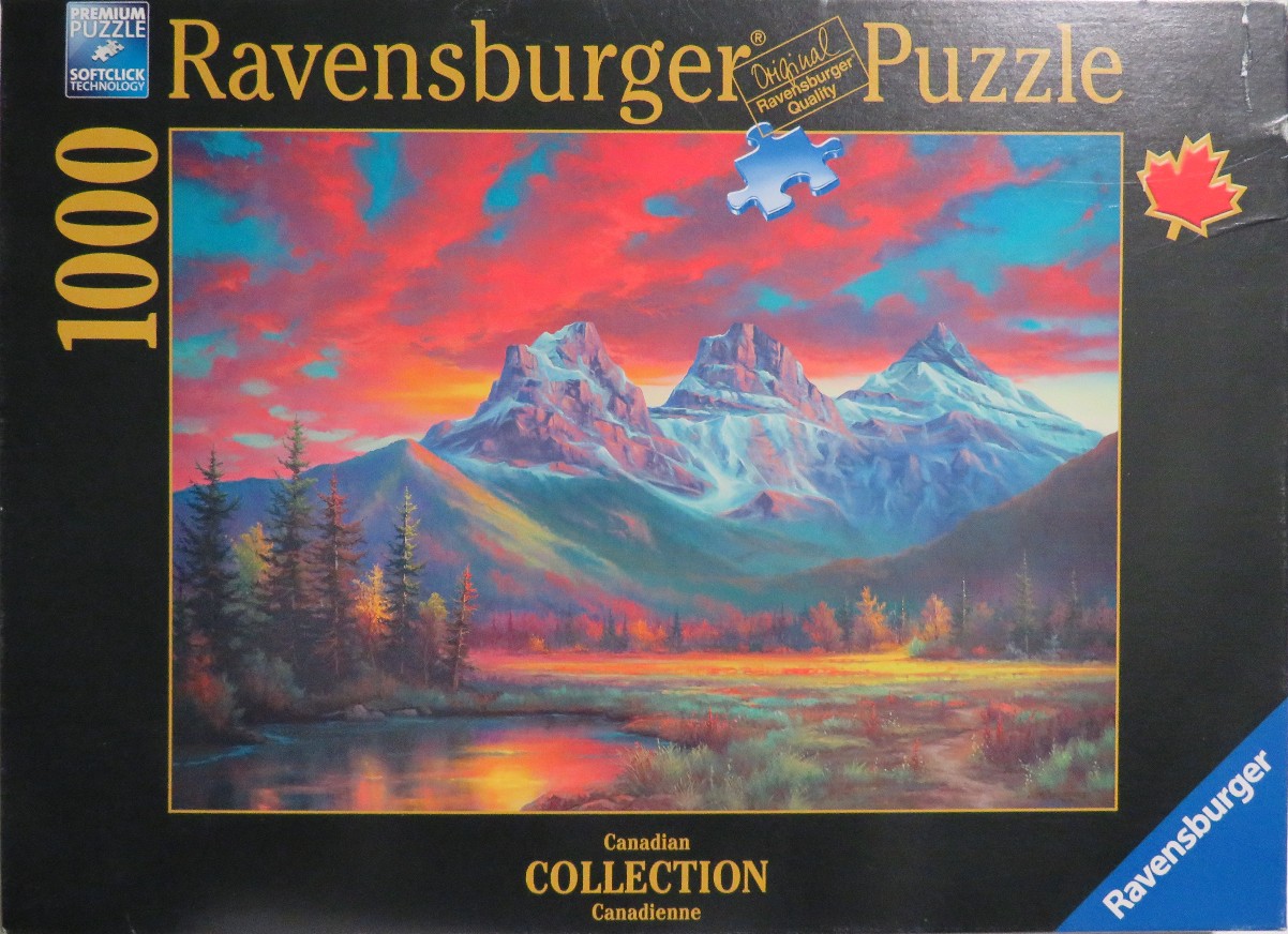 Oil painting of the Three Sisters mountains in Canada at sunset with a vibrant red and blue sky over a tranquil lake.