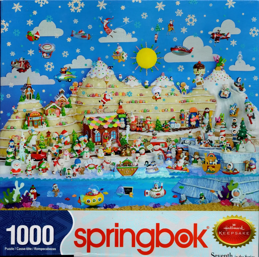 Whimsical 3D Christmas village diorama with candy-covered mountains, snowmen, and festive vehicles against a blue sky.