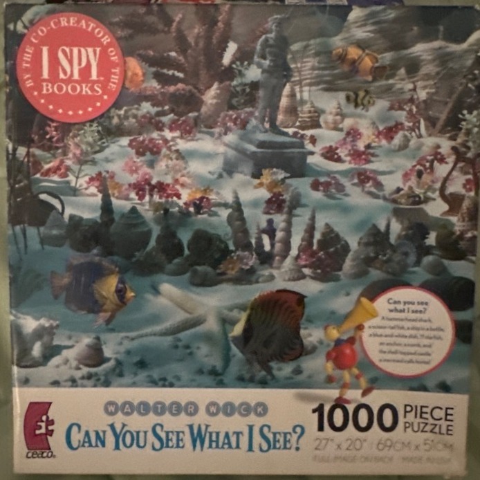 An underwater scene featuring a statue on a sandy floor, various fish, seashells, and coral.