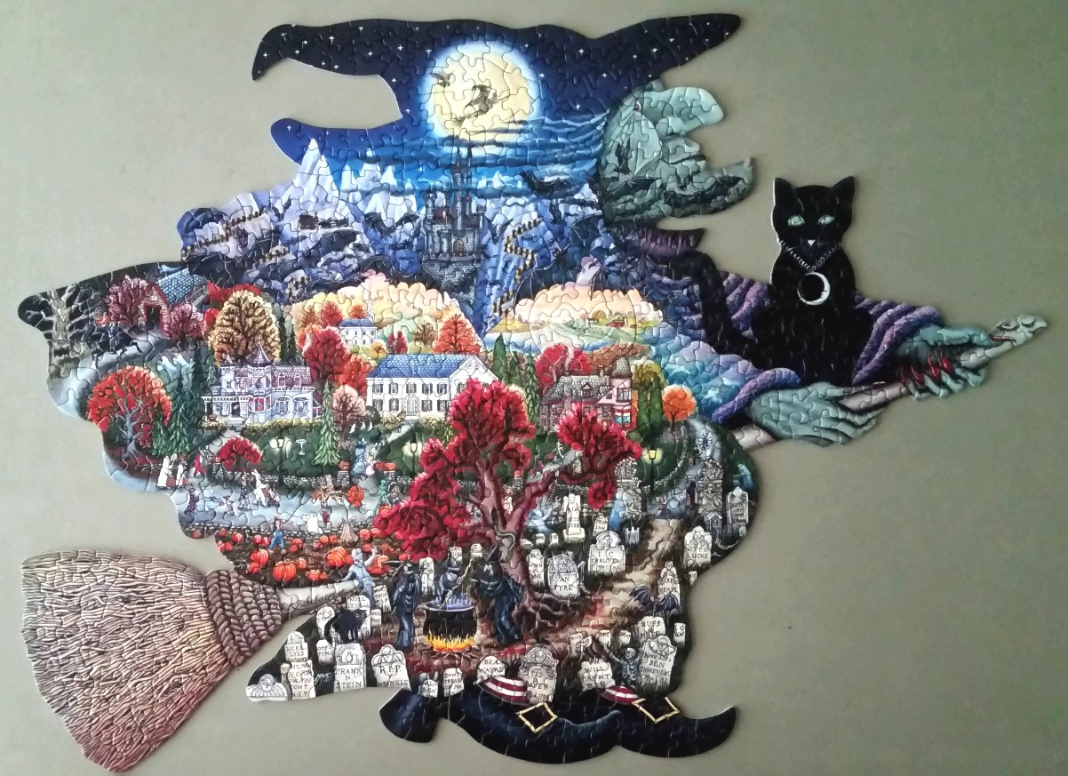 Silhouette of a witch flying on a broomstick, filled with a vibrant Halloween village and cemetery scene.