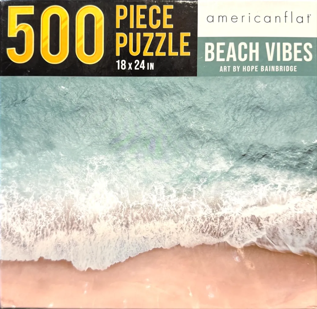 Aerial view of turquoise ocean waves washing onto a soft sandy beach