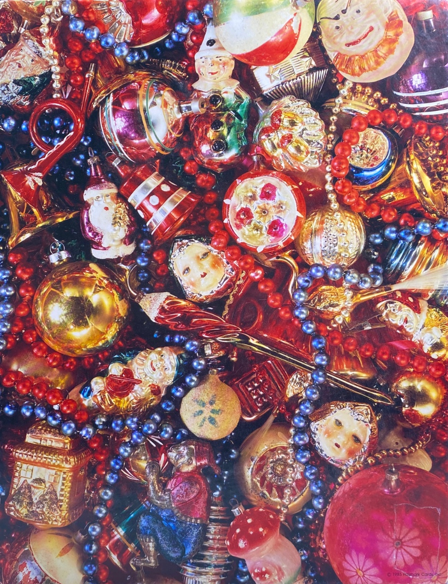 A close-up pile of vintage, multi-colored glass Christmas ornaments and beaded garlands.
